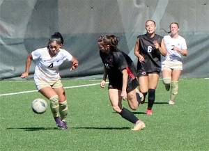 Peninsula College womens newcomer Kamalani Yamashita (4) from Hawaii battles for the ball against Central Washington in a scrimmage held last week at Wally Sigmar Field. In the background is Peninsulas Olivia Danks (2). (Dave Logan/for Peninsula Daily News)