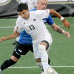 KEITH THORPE/PENINSULA DAILY NEWS Peninsulas Ezrah Ochoa, front, dribbles past Rogues Mason Klipfel during Fridays match at Wally Sigmar Field. In the background is Ochoas teammate Rei Sato.