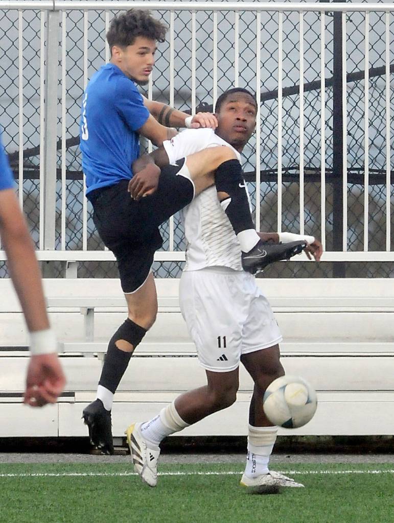 KEITH THORPE/PENINSULA DAILY NEWS Rogues Sammy Bayer, left, tries to go up and over Peninsulas Austin Collins on Friday at Peninsula College.