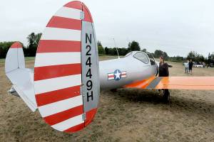 Josephine Camacho of Sequim examines a 1946 vintage Ercoupe 415-C belonging to Kevin and Charlene Tracy of Diamond Point as it sits on display during the Olympic Peninsula Air Affaire on Saturday at Sequim Valley Airport. The fly-in event featured modern and classic aircraft, as well and an antique auto show, displays, food and music. (Keith Thorpe/Peninsula Daily News)