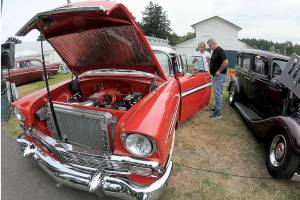 Vintage car owner Alfred Dese of Port Angeles, left, describes automotive details to Bob York of Port Angeles as they examine Deses 1956 Chevrolet Bel Air during Saturdays fourth annual John Burkheimer Memorial Car Show & Chili Cook-Off at the Clallam County Fairgrounds. Dozens of antique and vintage automobiles were featured at the event, which also included the cookoff as well as other food and music as a benefit for the Kiwanis Club of Port Angeles, which hosted the show. (Keith Thorpe/Peninsula Daily News)