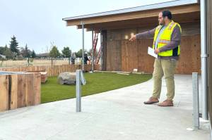 North Olympic Library System Executive Director Noah Glaude gestures to the outdoor childrens area of the Sequim Library, which features benches, a rock and bouncy turf along with a soon-to-be installed gate and a door directly into the inside childrens area. (Matthew Nash/Olympic Peninsula News Group)