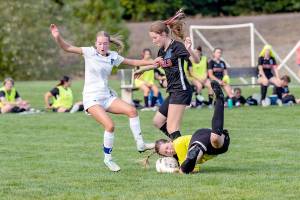 Steve Mullensky/for Peninsula Daily News

East Jefferson Rival's keeper Lila Morgan makes a diving save off the foot of Bellevue Christian's Emily Eggers as Rivals Fern French (16) during a Nisqually League game played on Tuesday at HJ Carroll Park in Port Hadlock.