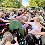 A crowd of about 120 people bless a totem pole and 10 cedar masks carved by the Lummi Nations House of Tears outside of the Capitol building in Olympia on Monday as part of the Indigenous-led campaign Xaalh and the Way of the Masks. The totem and masks will travel 1,700 miles between rally sites in Washington and Oregon before its given to the Lower Elwha Klallam Tribe west of Port Angeles on Sept. 20. (Emily Fitzgerald/Washington State Standard)
