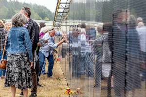 Frank Arey of Port Hadlock rubs his uncle Stephen R Lopemans name that is etched in the three-quarter scale Vietnam Veterans Memorial on display at Jefferson County International Airport until 2 p.m. Sunday. Lopeman, a 1968 Port Townsend High School graduate, died in Vietnam in 1969. (Steve Mullensky/for Peninsula Daily News)