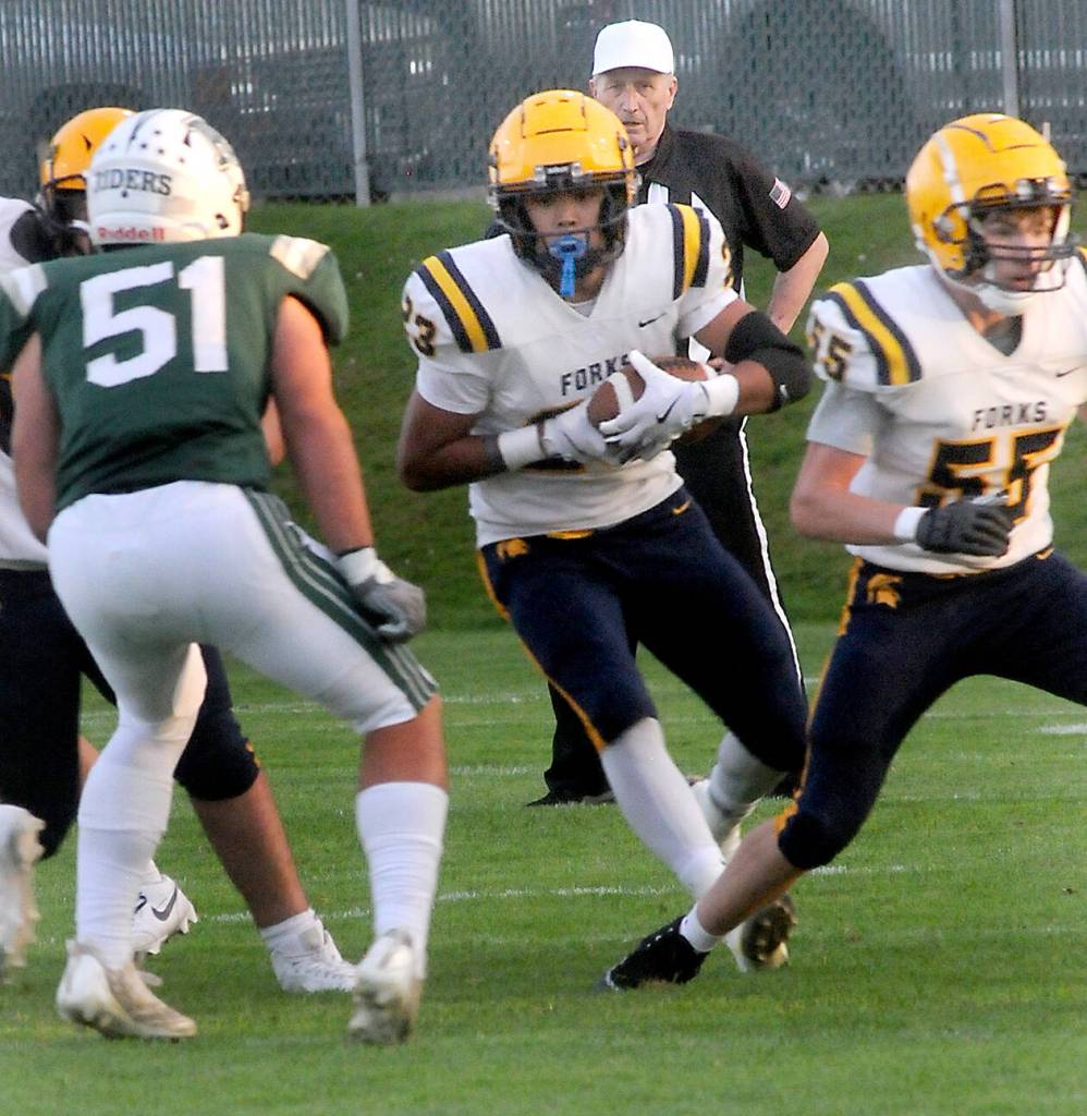 KEITH THORPE/PENINSULA DAILY NEWS
Forks tight end Kaden Ward, center, scrambles for a way past Port Angeles' Hunter Flores as teammate Conner Roberts, right, sets up a block on Friday evening in Port Angeles.