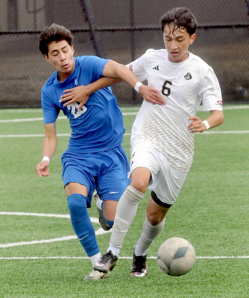 Edmonds Angel Jimenez, left, and Peninsulas Noe Garfias push off each other near midfield on Saturday in Port Angeles. (Keith Thorpe/Peninsula Daily News)