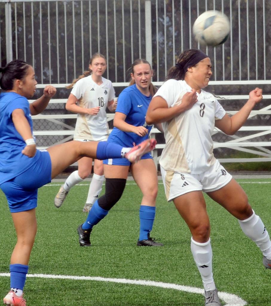 Peninsulas Isis-Jada Bryant, left, deflects a ball against her head kicked by Edmonds Priscella Lam, left, on Saturday in Port Angeles. Looking on are Peninsulas Cailey Ridgeway and Edmonds Kari Adams. (Keith Thorpe/Peninsula Daily News)