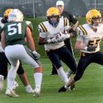 Forks tight end Kaden Ward, center, scrambles for a way past Port Angeles Hunter Flores as teammate Conner Roberts, right, sets up a block on Friday evening in Port Angeles. (Keith Thorpe/Peninsula Daily News)