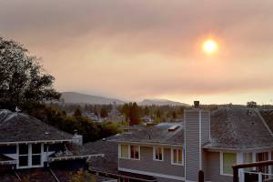 The sun shines through a layer of clouds and wildfire smoke as it begins to set on Tuesday in Port Angeles. (Keith Thorpe/Peninsula Daily News)