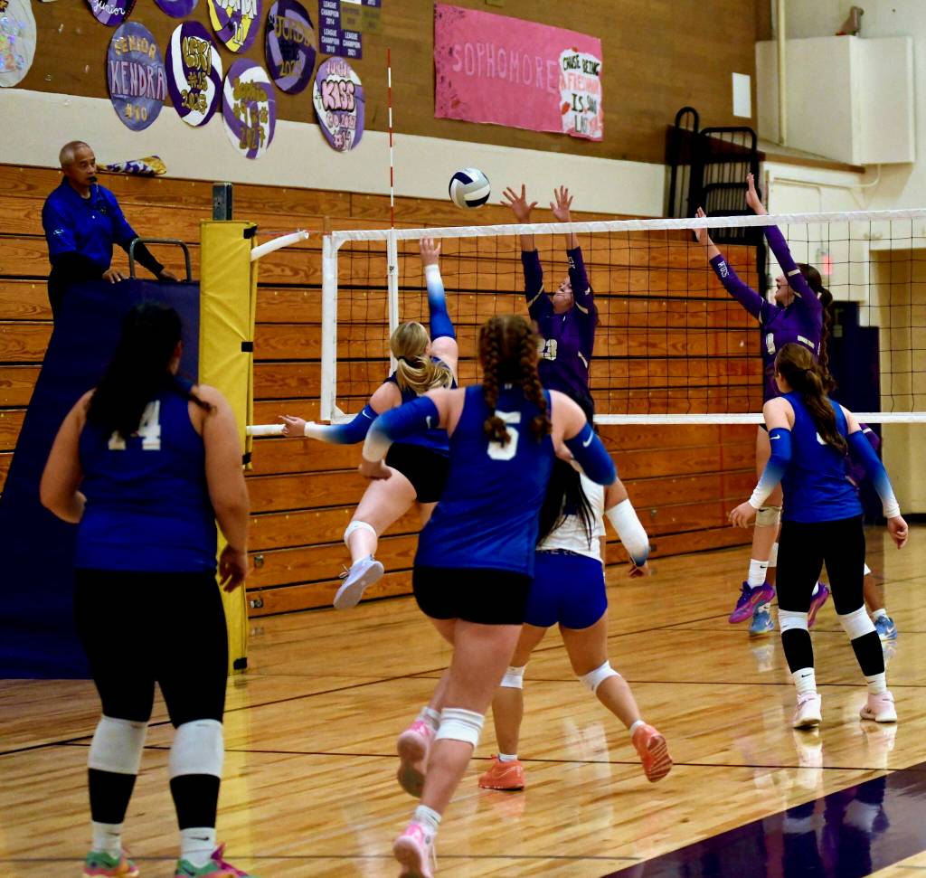 Sequim defensive specialist Illz uinene #23 battles over dominance of the court with Trojan Settter Teagan Earl #9.