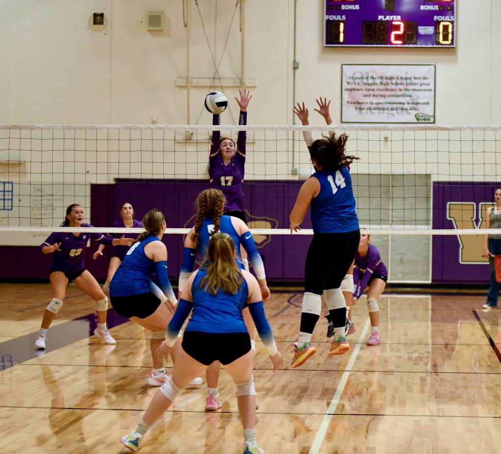 Sequim Wolf Tegan Neathery #9 makes the block as Trojan Middle Hitter Kenzie Newcomb-Williams prepares for the consequences.