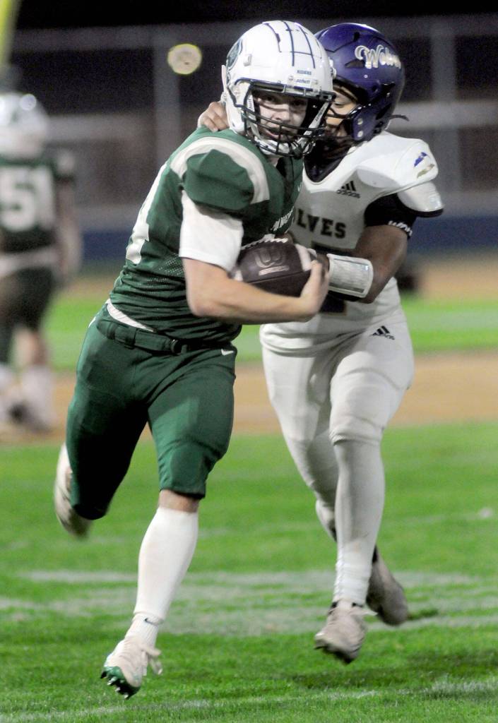 KEITH THORPE/PENINSULA DAILY NEWS
Port Angeles' Jude Wallace, left, slips by the defense of Sequim's Josiah Tuller on Friday night at Port Angeles Civic Field.