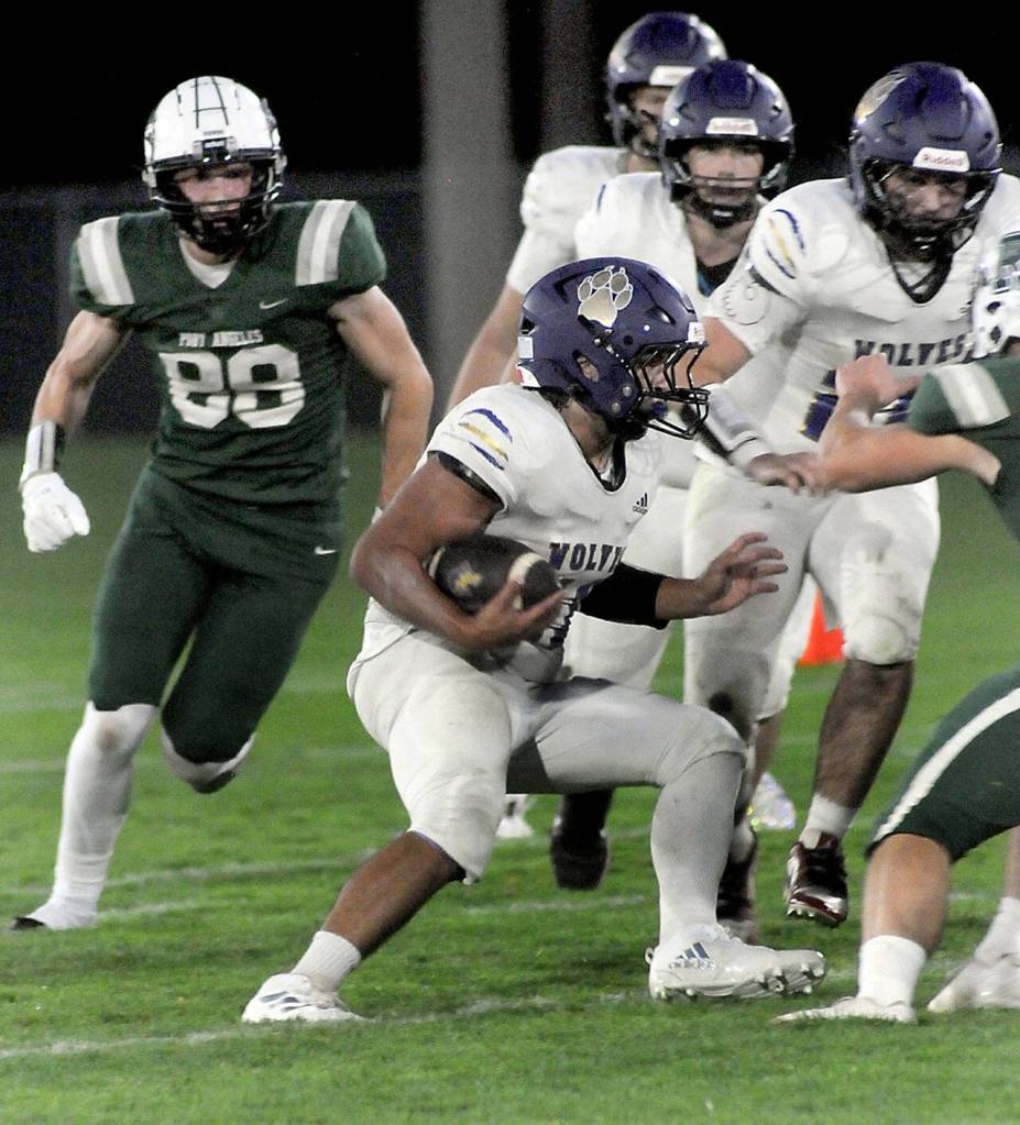 KEITH THORPE/PENINSULA DAILY NEWS
Sequim's Liam Wiker, center, looks for blocking from his teammates as Port Angeles' Taylor Abold closes in at left on Friday night in Port Angeles.