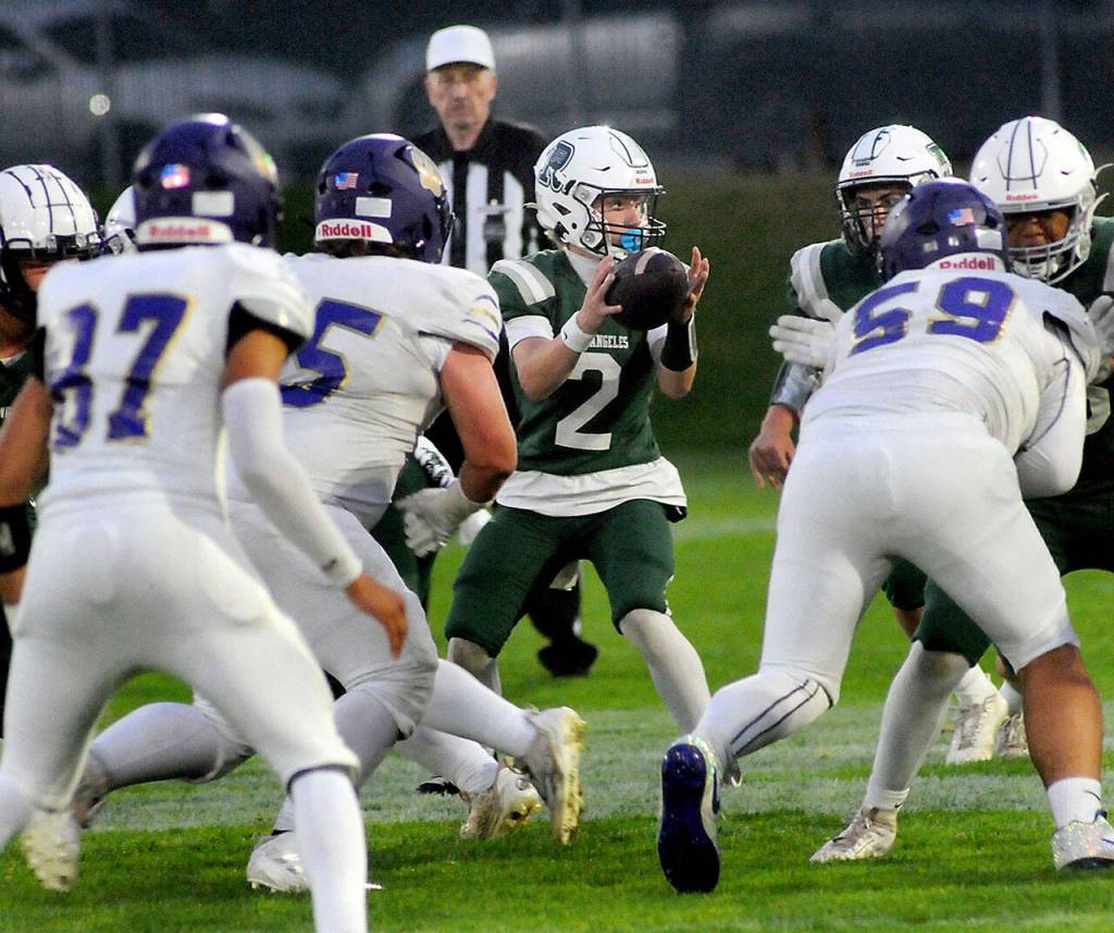 KEITH THORPE/PENINSULA DAILY NEWS
Port Angeles quarterback Carson Waddell, center, receives the shotgun as he looks through the Sequim defensive line for an opening on Friday evening in Port Angeles.
