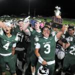 KEITH THORPE/PENINSULA DAILY NEWS Port Angeles Asante Korsmo holds up the Rainshadow Rumble trophy as he and the rest of his Roughriders team celebrate Friday nights 27-14 victory over Sequm at Port Angeles Civic Field.