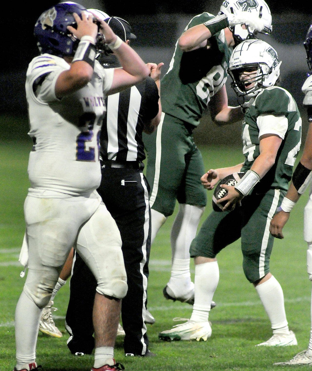 Sequims Patrick Elias, left, expresses disbelief after Port Angeles Jude Wallace, right, completed a pass reception near the Sequim goal line while teammate Taylor Abold celebrates during Friday nights game in Port Angeles. (Keith Thorpe/Peninsula Daily News)