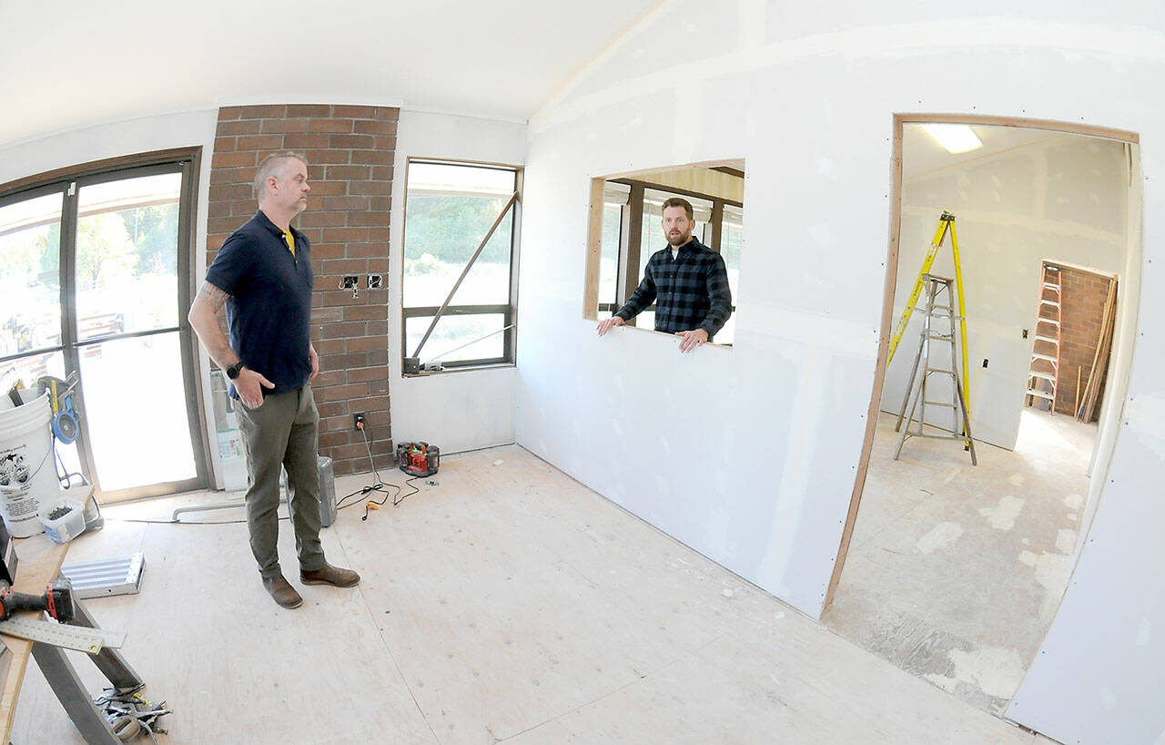 Trevor Sly, operations manager of Olympic Hiking Co., left, and Tommy Farris, company owner and general manager, discuss relocating their business from The Wharf on the Port Angeles Waterfront to a new office on West Marine Drive. (Keith Thorpe/Peninsula Daily News)