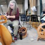 Sarah Severns, left, and Diana Burns, both of Sequim and members of the North Olympic Shuttle & Spindle Guild, operate a pair of spinning wheels at a demonstration table at the Pacific Northwest Fiber Arts Expo on Friday at Vern Burton Community Center in Port Angeles. The three-day festival featured dozens of vendor displays, workshops and demonstrations that supported knitting, weaving and other fiber activities. (Keith Thorpe/Peninsula Daily News)
