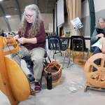 Sarah Severns, left, and Diana Burns, both of Sequim and members of the North Olympic Shuttle & Spindle Guild, operate a pair of spinning wheels at a demonstration table at the Pacific Northwest Fiber Arts Expo on Friday at Vern Burton Community Center in Port Angeles. The three-day festival featured dozens of vendor displays, workshops and demonstrations that supported knitting, weaving and other fiber activities. (Keith Thorpe/Peninsula Daily News)