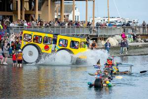 Racers make a big splash as they hit the water after rolling down the boat ramp at Northwest Maritime on Saturday. The 14 entrants in the Kinetic Skulpture race had to prove their floatability by paddling across the bay to the Port Townsend city dock, about a quarter-mile, and back to the ramp before they could participate in Sundays event. (Steve Mullensky/for Peninsula Daily News)