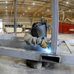 Hailey Robinson welds a steel frame on a component of a temporary military billet being constructed at Composite Recycling Technology Center's Port Angeles facility. (Keith Thorpe/Peninsula Daily News)