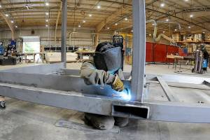 Hailey Robinson welds a steel frame on a component of a temporary military billet being constructed at Composite Recycling Technology Center's Port Angeles facility. (Keith Thorpe/Peninsula Daily News)