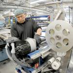 Grant Ledesma spools tape around a component of a portable housing unit being built at Composite Recycling Technology Center in Port Angeles. (Keith Thorpe/Peninsula Daily News)