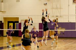 Sequim's Kassi Montero battles above the net against unbeaten Bainbridge in a match Tuesday in Sequim. Also in on the play are Sequim's Kenzie Berglund (23) and Teagan Neathery (17). (Jacques Star/Olympic Peninsula News Group)
