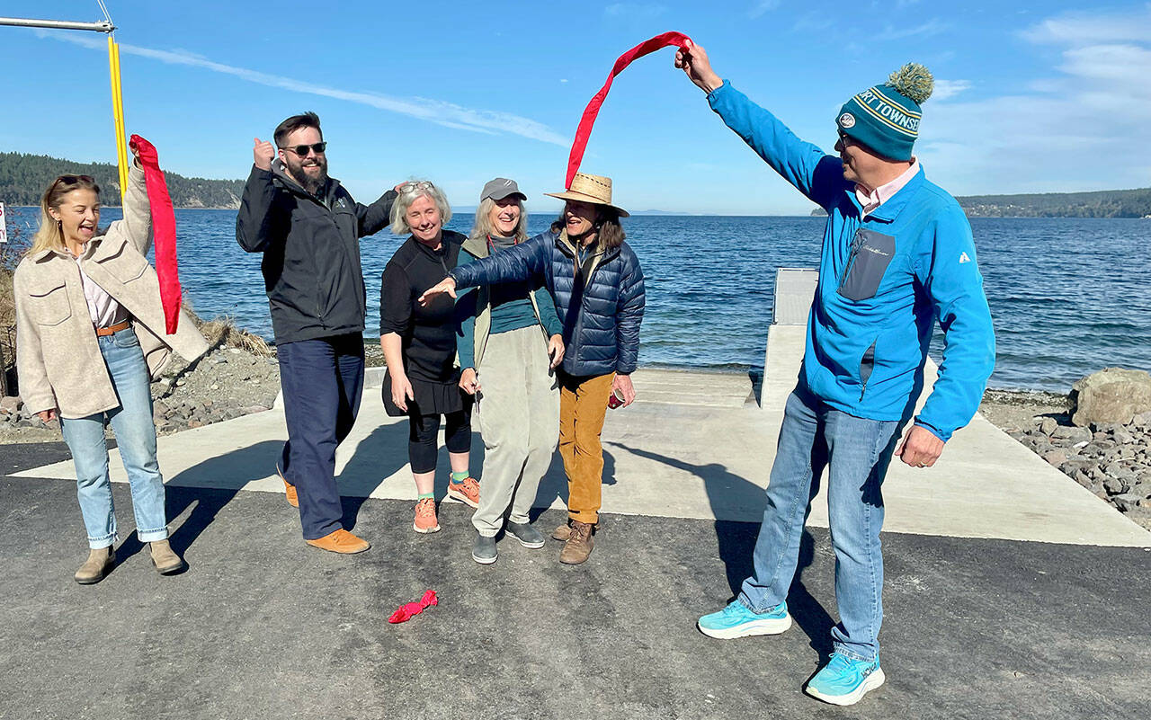 Port of Port Townsend project administrator Natalie Toews, left, Washington Recreation and Conservation Office Outdoor Grants Manager Brian Carpenter, Jefferson County Commissioner Heidi Eisenhour, Port of Port Townsend commissioners Carol Hasse and Pam Petranek and Port Executive Director Eron Berg cut the ribbon at the new Gardiner boat ramp and ADA-compliant boat launch on Discovery Bay. (Paula Hunt/Peninsula Daily News)