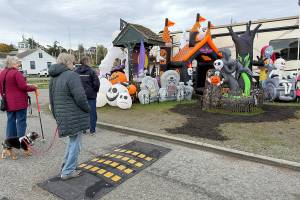 A group of friends stop to look at a Halloween display put up by the camp host at the RV park at Point Hudson Marina. (Steve Mullensky/for Peninsula Daily News)