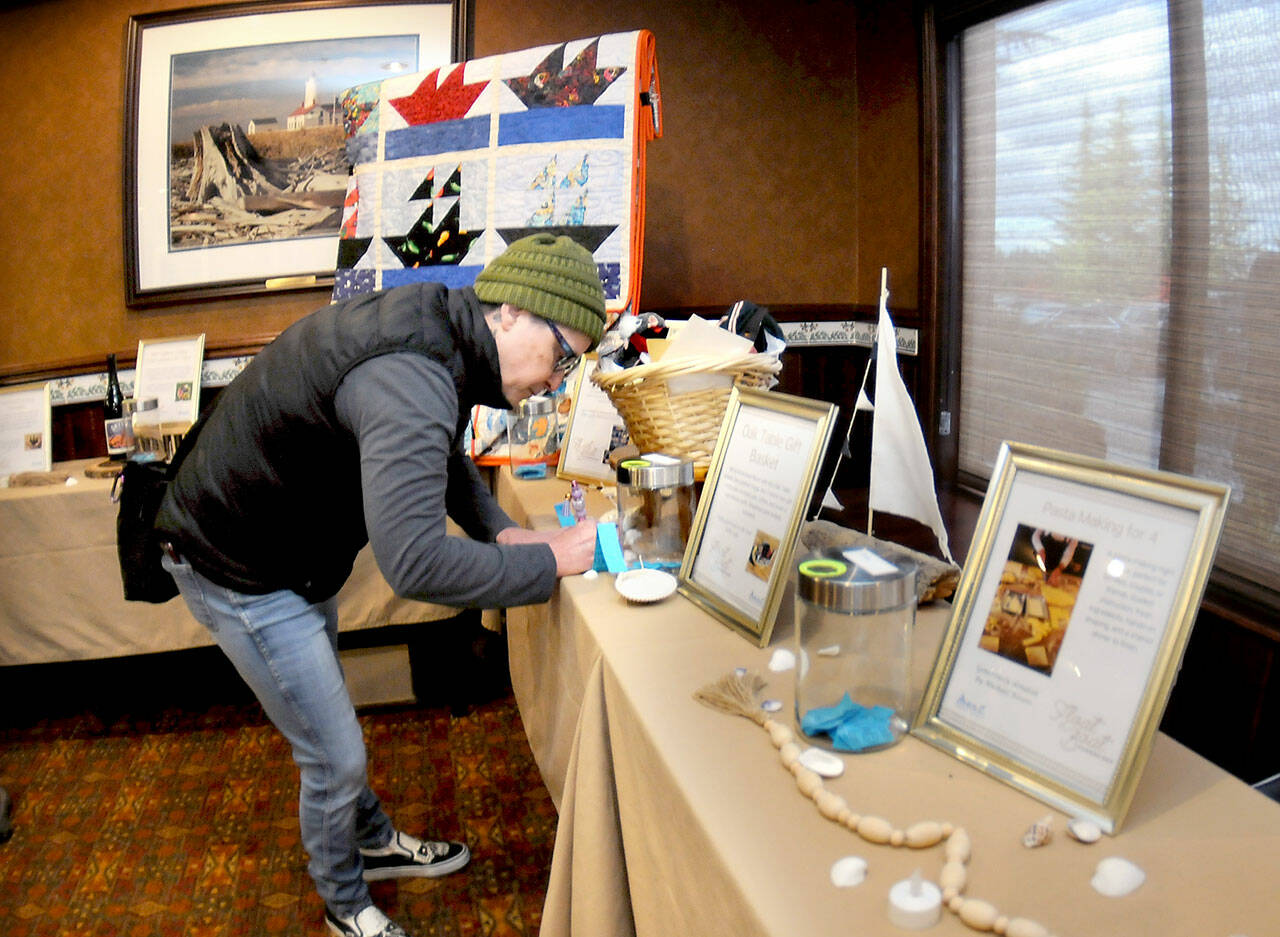 Rachel Anderson of Port Angeles fills out a raffle ticket for gifts and nautical-themed items during Wednesdays Float the Boat fundraiser benefitting the Port Angeles junior and senior high school sailing teams. The event, held at Olympic Lodge by Ayres in Port Angeles, was conducted by the nonprofit Community Boating Program to support youth sailing and other nautical programs. (Keith Thorpe/Peninsula Daily News)