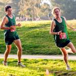 OlympicLeagueXC-PDN-251025 Emily Matthiessen/for Peninsula Daily News Port Angeles boys runners Andre Campbell, left, and Easton Dempsey round a turn during the Olympic League Cross Country Championships at The Cedars at Dungeness Golf Course on Thursday.