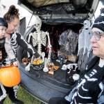 Jessica Topham of Sequim collects sweet treats for her son, Ivar Baker, 19 months, as Becky Rice looks on from her spookily decorated vehicle during Saturdays Country Fair and Trunk or Treat at the Sequim Prairie Grange north of Carlsborg. The Halloween-themed event featured food, games, pumpkin carving and scary treats, hosted by members of the grange. (Keith Thorpe/Peninsula Daily News)