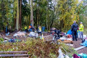 Port Townsend city employees work to clean up the Evans Vista homeless encampment on Thursday. The city hired Leland Construction of Roy to help with the process, which was initiated by the Port Townsend City Council in September. The city gave camp residents until Monday to vacate the premises and began the sweep of the area on Thursday. (Steve Mullensky/for Peninsula Daily News)