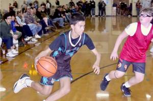 Port Angeles hosted the Fall Classic Basketball Tournament this weekend with 50 teams from as far away as Bainbridge and Everett. The tournament featured girls and boys from fourth through eighth grades playing games Saturday and Sunday at Port Angeles High School and Roosevelt and Stevens middle school gyms. Each division winner will have qualified for the state tournament in 2026. Here, Jack Jacobson, a Sequim Timberwolves seventh grader, drives around a player from Poulsbo. The Sequim Timberwolves won the game 50-25. (Dave Logan/for Peninsula Daily News)