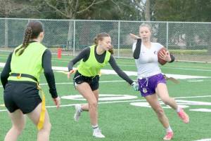 In a scrimmage last between the new Port Angeles and Sequim flag football squads, Sequim's Lily Sparks tries to avoid having her flag pulled by Port Angeles defender Audrey Rudd. On the left is Port Angeles' Miriam Cobb. (Dave Logan/for Peninsula Daily News)