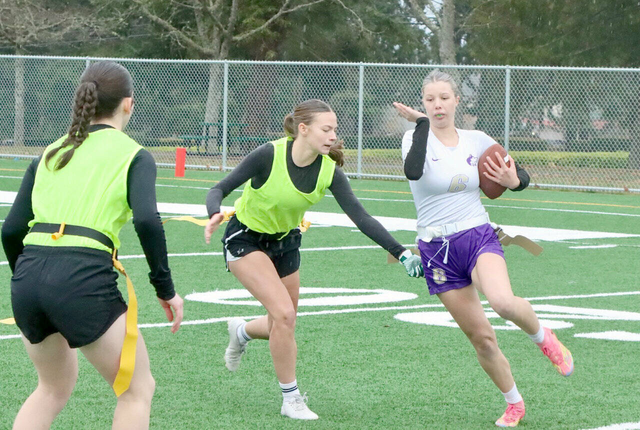 In a scrimmage last between the new Port Angeles and Sequim flag football squads, Sequims Lily Sparks tries to avoid having her flag pulled by Port Angeles defender Audrey Rudd. On the left is Port Angeles Miriam Cobb. (Dave Logan/for Peninsula Daily News)