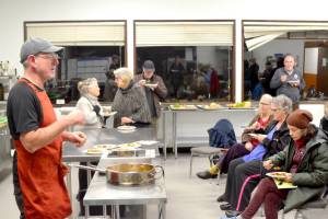 Chef Arran Stark speaks with attendees as they eat ratatouille  mixed roasted vegetables and roasted delicata squash  that he prepared in his cooking with vegetables class. (Elijah Sussman/Peninsula Daily News)