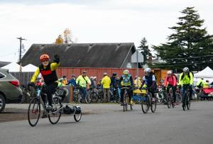 Denny Bellow, left, waves as he departs the Sequim Food Bank to collect food as part of the 15th annual Cranksgiving event on Nov. 22. Cranksgiving drew a record 84 cyclists and resulted in donations to the Sequim Food Bank of more than $6,400 and more than 2,000 pounds of food, Executive Director Andra Smith said. The event was open to riders of all ages and involves swag and prizes donated by local merchants and national bicycle brands. Over the years, it has brought in more than 10 tons of food and more than $27,000 in donations, with participants purchasing food from along Washington Street. (Monica Berkseth/For Olympic Peninsula News Group)