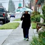 Sue Bahl walks with an umbrella on West Eighth Street on Monday. Heavy rainfall up to 8 inches over the past several days has increased the threat of landslides in Western Washington, according to the National Weather Service. A flood watch also has been issued until 4 p.m. Friday for portions of northwest and west central Washington, including Clallam and Jefferson counties. Sharp rises in rivers, especially those flowing off the Olympics and Cascades, are expected, the National Weather Service said. (Dave Logan/for Peninsula Daily News)