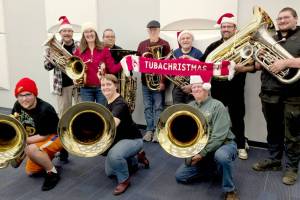 A dozen tuba and euphonium players from the Sequim City Band gather with their instruments and a signature red TubaChristmas scarf as they prepare for this years TubaChristmas performance in Port Angeles. (Sharron McClelland/Sequim City Band)