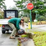 Patrick Zolpi-Mikols, a park aide with Fort Worden State Park, gathers and removes leaves covering the storm drains after an atmospheric river rainstorm early Wednesday morning in Port Townsend. A flood warning was issued by the National Weather Service until 11:11 a.m. today for the Elwha River at the McDonald Bridge in Clallam County. With the flood stage at 20 feet, the Elwha River was projected to rise to 23.3 feet late Wednesday afternoon and then fall below flood stage just after midnight. (Steve Mullensky/for Peninsula Daily News)