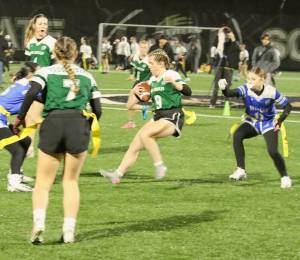 Dave Logan/for Peninsula Daily News 
Port Angeles Allison Fricker avoids Olympic Trojan Kathryn James, right, trying to strip her flag during their flag football match Thursday evening in a heavy mist at Wally Sigmar Field at Peninsula College. The Roughriders beat Olympic 42-0 and Kingston 42-35 to improve to 3-1. Sequim (3-1) edged North Kitsap 15-14 and lost to Klahowya 35-6.