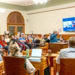 Judy Krebs of Port Townsend speaks to the Port Townsend City Council on Monday to voice her concerns regarding the councils pending vote on the 2026 Comprehensive Plan and development regulations. Krebs holds a sign that reads pause, as do others, entreating the council to delay its vote on passing the plan. About 65 citizens filled the chamber to capacity for the meeting. (Steve Mullensky/for Peninsula Daily News)