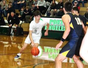 Port Angeles' Brody Pierce drives the lane against Bainbridge on Friday in Port Angeles. The short-handed Roughriders kept pace with the Spartans until the final three minutes of the first half. (Dave Logan/for Peninsula Daily News)