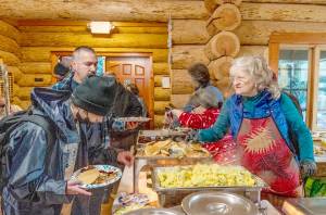 Volunteers serve up a full breakfast on Christmas morning, for the Third Community Breakfast at the Fred Lewis Scout Cabin in Port Townsend put on by the Reach Out Community Organization, a homeless advocacy program. A full breakfast was served to about 150 people during the morning. On the serving line are, from the back, Rose Maerone, Marie France and Susan Papps. (Steve Mullensky/for Peninsula Daily News)