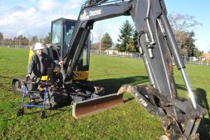 Marylaura Ramponi stands by an excavator donated for geotechnical work at Sequim School District by Jamestown Excavating. She donated $1 million for the naming rights of the Ramponi Center for Technical Excellence, a career and technical education building that will be built in conjunction with new buildings at Sequim High School. (Matthew Nash/Olympic Peninsula News Group)