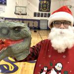 Justice Loftus holds up a dinosaur mask he received at the Winter Wishes assembly. He said he plans to use it to play with his younger brother. (Matthew Nash/Olympic Peninsula News Group)