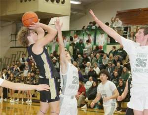 Sequim's Zeke Schmadeke shoots against the defense of Port Angeles's Ashton Gedelman (20) and Abe Brenkman (35). Keilar Point (23) is also on the floor. (Dave Logan/for Peninsula Daily News)